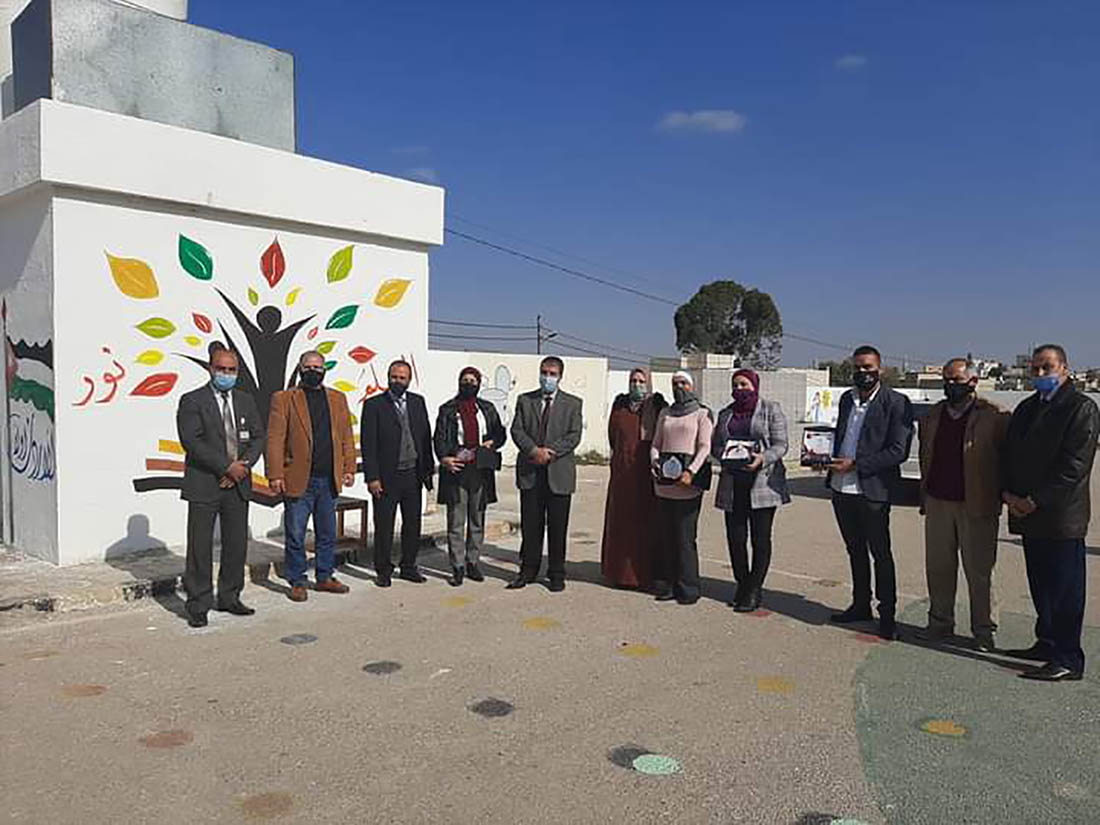 معلمات يرسمن جداريات مبرة على أسواعر مدرستهن